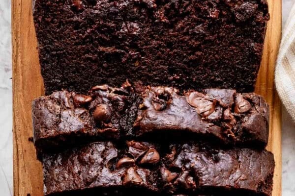 sliced loaf of chocolate banana bread on loaf shaped cutting board.