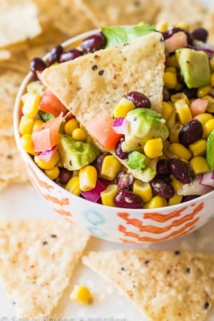 avocado corn salsa in a colorful bowl with chips